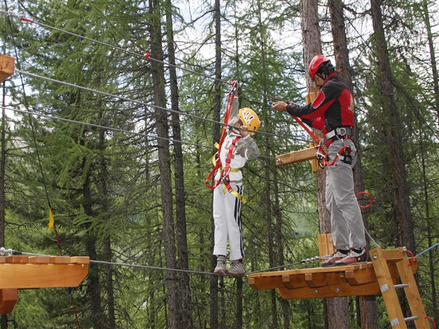 Un coraggioso cammina su di una corda sospesa in mezzo ad un sacco di alberi verdisimi!